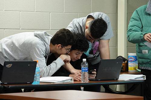 Students looking a a screen together.